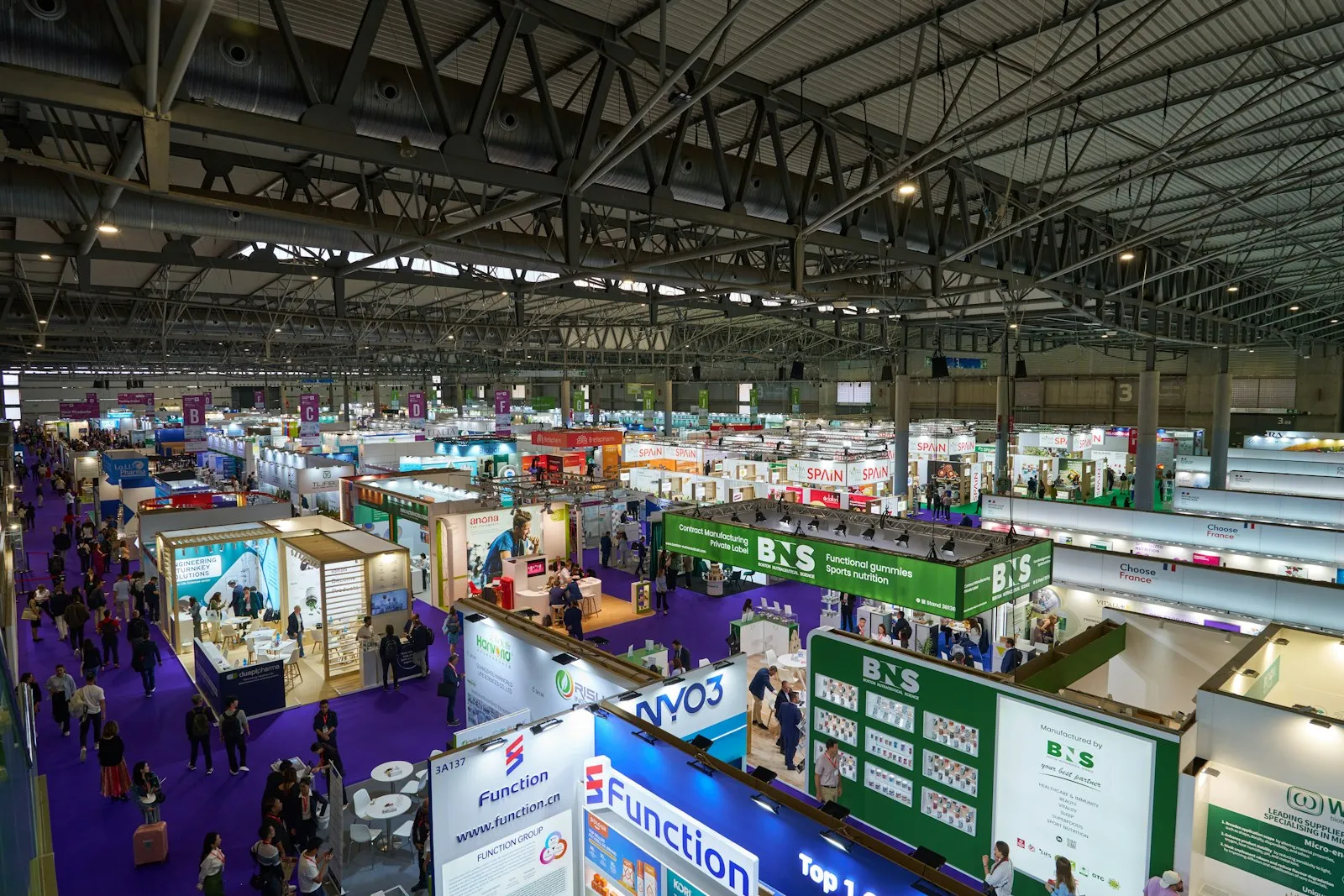 Messehalle mit Ausstellern und Besuchern